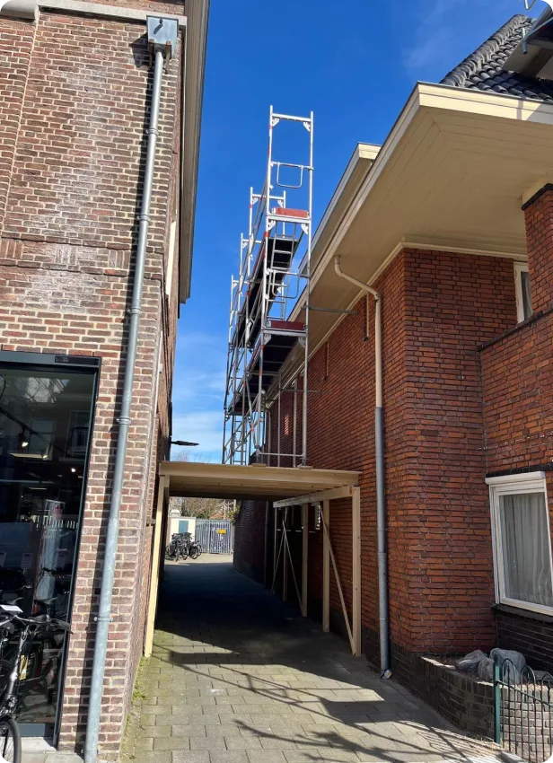 Smalle steiger boven een doorgang tussen twee woningen